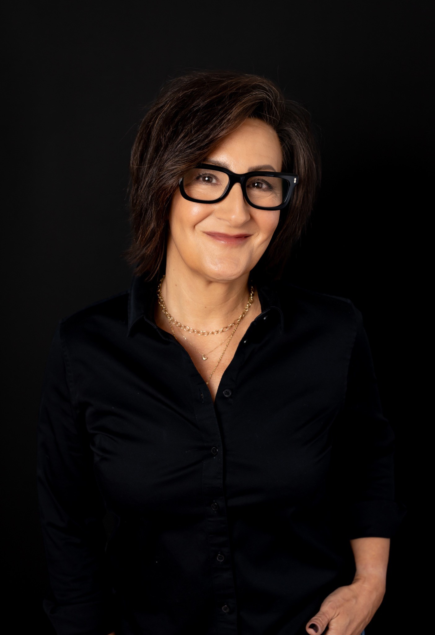 Nikki Johnson smiling in a black shirt against a dark background